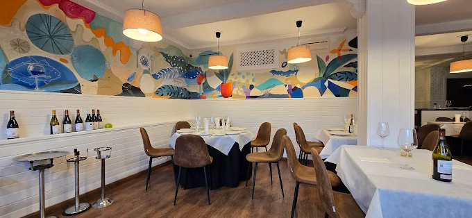 Comedor interior con mural colorido y mesas vestidas